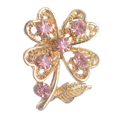 A golden brooch pin in the shape of a rose with shiny lobes