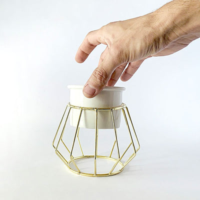 Decorative ceramic vase with a gold metal stand in a geometric shape