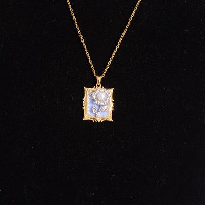 سلسلة رفيعة بدلاية شكل برواز مربع بداخله وردة بارزة لون ذهبي