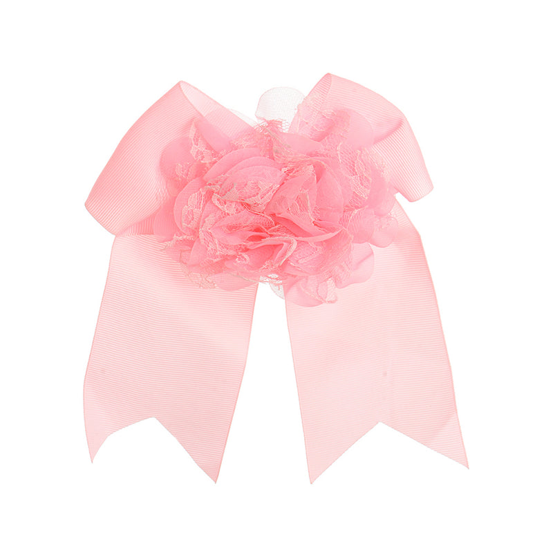 A hair clip in the shape of a pink bow