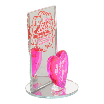 A decorative glass heart with a fuchsia circular mirror base