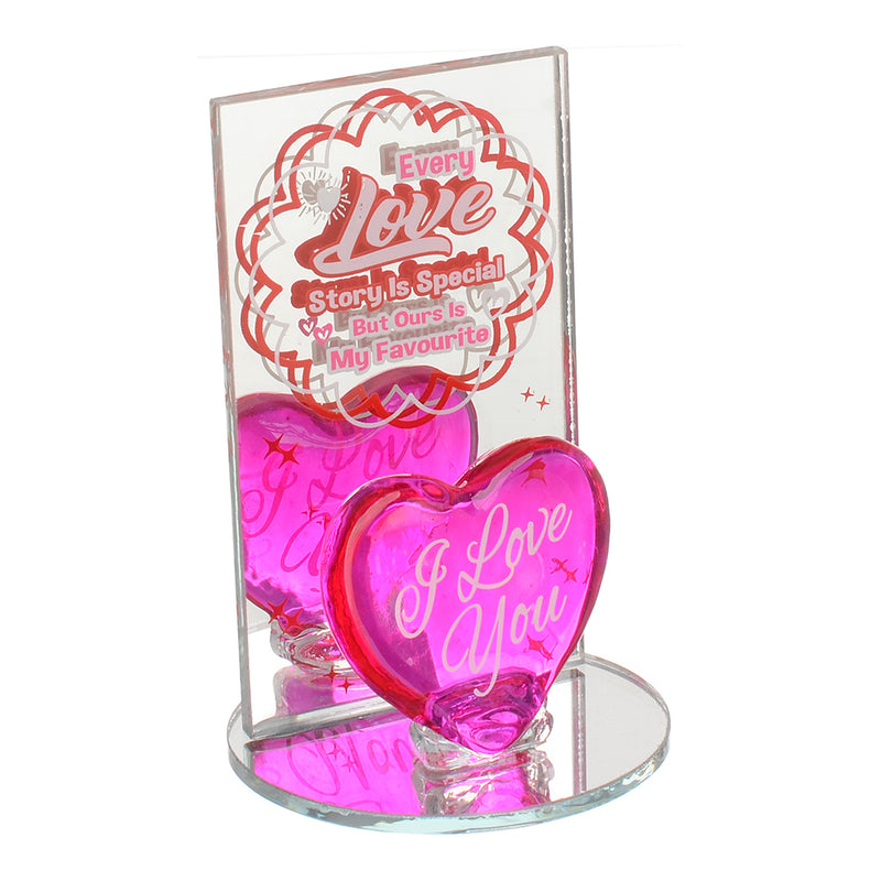 A decorative glass heart with a fuchsia circular mirror base